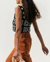 Brazalete rígido de diseño minimalista con forma de espiral, elaborado artesanalmente en bronce y alpaca maciza. Es una pieza ajustable que puede lucirse tanto en el antebrazo como en la parte superior del brazo.