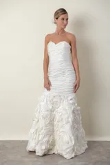 Vestido de novia blanco strapless, con cuerpo drapeado y falda con diseño de flores en tafeta.