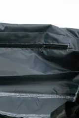 Bolso de viaje gris con doble asa corta y cierre superior. Estampado frontal con la frase "The Tote Bag" en letras blancas.