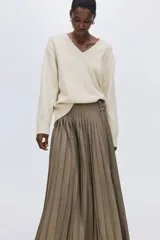 Buzo oversized de punto suave, con cuello en V, hombros caídos y terminaciones acanaladas en cuello, puños y bajo.