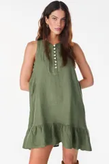 Vestido corto de lino verde militar, sin mangas, con corte suelto y liviano. Presenta tapeta frontal con botones de nácar y un volado fruncido en el ruedo.