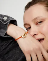 Pulsera de cuero trenzado color naranja con cierre de mosquetón entrelazado bañado en oro de 18k.