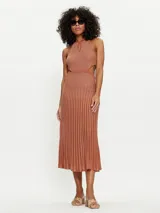 Vestido midi de punto color ladrillo con lurex, cuello halter con abertura en forma de lágrima y falda plisada con cortes en los laterales.