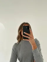 Remera gris de morley de algodón, manga larga con detalle fruncido en el hombro.