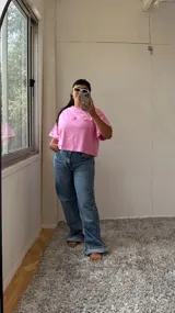 Remera rosa de corte cuadrado con logo bordado en rojo.