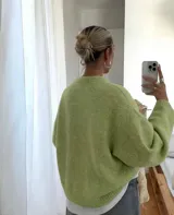 Sweater de punto en color verde matcha, con diseño oversized, cuello redondo y mangas amplias de corte relajado.