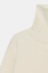 Jersey de punto liso confeccionado con lana, con cuello subido, manga larga y acabados en rib.