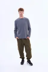 Buzo de manga larga con textura tipo waffle, cuello redondo y corte holgado.