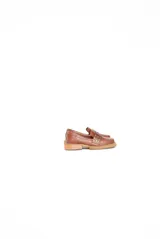 Mocasín de cuero color suela con punta cuadrada y detalle de tachas metálicas en la faja frontal. Cuenta con suela de caucho con vira a la vista.