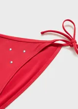 Top de bikini rojo con apliques metálicos.