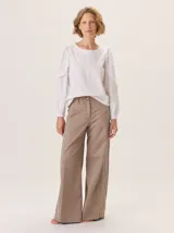 Pantalon de pierna ancha con detalles de pespuntes a contratono y tira lateral decorativa. Cuenta con cierre frontal y boton.