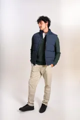 Chaleco puffer de color azul marino, con cierre frontal completo y cuello alto. Presenta un diseño acolchado horizontal y el logo de la marca bordado en el pecho.