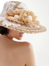 Sombrero de rafia color beige con apliques de encaje y flores de rafia.