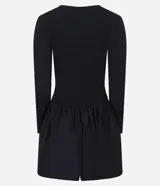 Vestido corto negro con parte superior ajustada de rib y falda globo de tricolina acanalada. Tiene cuello redondo y mangas largas.