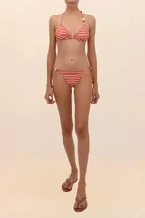 Calzón de bikini reversible con estampado floral en tonos naranja y blanco, con tiras laterales ajustables y cuentas decorativas.