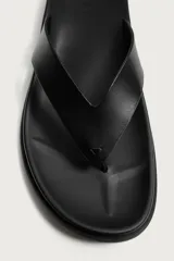 Sandalias de dedo color negro con suela plana y tiras anchas en el empeine con diseño de chancleta.