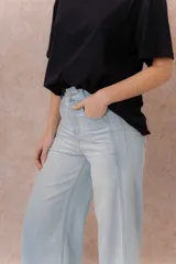 Pantalón jean tiro alto de color celeste claro, con corte wide leg y largo cropped. Presenta bolsillos funcionales y terminación de ruedo ancho.