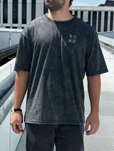 Remera gris con efecto gastado, corte oversize, mangas cortas y estampado en la espalda con el texto "SUPPLY GOODS DESIGNED IN PUNTA DEL ESTE".