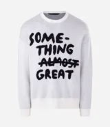 Suéter de corte boxy confeccionado en tejido jacquard de viscosa y poliéster. Presenta cuello redondo, mangas largas y un diseño estampado con lettering en color negro sobre fondo blanco.