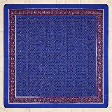 Pañuelo de seda azul con diseño estampado de patrones geométricos y cenefa decorativa en tonos rojos y marrones.