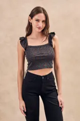 Top corto ajustado al cuerpo con escote cuadrado y volados en los hombros. Tejido de punto con hilo lurex multicolor que le da un efecto brillante.