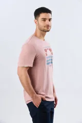 Remera blanca de manga corta y cuello redondo, con estampa frontal inspirada en el mar y atardeceres de verano con la inscripción 'Travel. Beach. Repeat.' y 'Legacy'.
