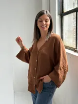 Camisa de lino color tabaco, con escote en V y cierre frontal con botones.