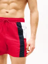 Short de baño rojo con cintura elástica ajustable con cordón, logo de Tommy Hilfiger estampado en el lateral y detalles en azul marino y blanco.