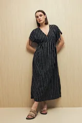 Vestido largo negro con estampado de rayas verticales blancas, escote en V y mangas cortas con lazo regulable.