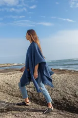 Ruana azul marino de tejido grueso con flecos en el borde.