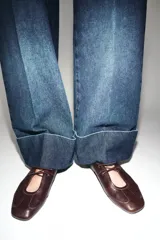 Jeans de tiro bajo con pernera recta y bajo con vuelta. Cuenta con cinco bolsillos y cierre frontal con cremallera y botones.