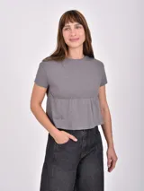 Remera gris oscuro de corte peplum con cuello redondo y mangas cortas, confeccionada en tejido de punto con textura.