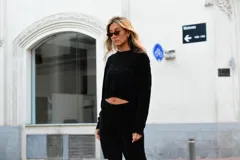 Buzo negro de punto crop, de manga larga y cuello redondo.