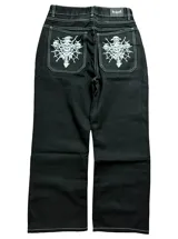 Jean negro de corte regular fit, con bolsillos traseros amplios que cuentan con un estampado gráfico en color blanco de calaveras y diseño gótico.