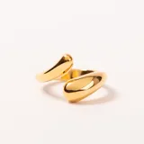 Anillo abierto de acero enchapado en oro, con diseño de dos formas orgánicas y pulidas en los extremos.
