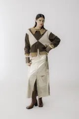 Chaqueta bomber azul marino con paneles color mostaza en forma de rombos. Tiene cuello tipo camisa, cierre frontal con cremallera, bolsillos de parche y puños y bajo acanalados en color marrón.