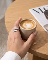 Anillo abierto en espiral de acero inoxidable, adornado con inserciones de nácar y detalles de circonitas pavé.