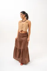 Pollera larga marrón de tiro medio, confeccionada en lino con diseño en niveles y vuelo.