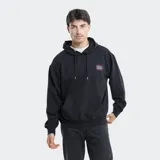 Canguro con capucha y cordones ajustables, color verde grisáceo. Presenta un bolsillo frontal tipo canguro y un parche bordado en el pecho con diseño de marca. Posee puños y ruedo acanalados.