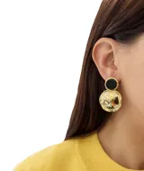 Aros colgantes dorados con un círculo superior blanco y un círculo inferior dorado con textura.