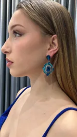 Aros colgantes con forma de lágrima y diseño de flores con cristales azules.
