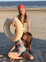 Traje de baño enterizo de niña, con estampado de hojas y círculos, manga corta y moño en la espalda.