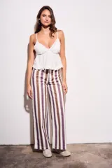 Pantalón de jean de corte wide leg, tiro medio, con rayas verticales en tonos marrón, morado y blanco crema.