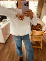 Remera blanca de algodón con cuello redondo y bordados en el contorno.