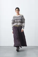 Falda larga de corte amplio y fluido, confeccionada en tela con textura arrugada. Presenta una silueta voluminosa y cómoda, ideal para un estilo relajado.
