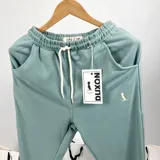 Pantalón de jogging verde agua claro, con cintura elástica ajustable con cordón, bolsillos laterales y puños en los tobillos.