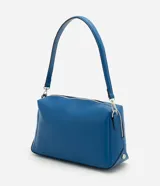 Bolso tipo shoulder de diseño rectangular estructurado en color azul. Cuenta con cierre metálico superior, herrajes plateados y correa larga ajustable y removible.