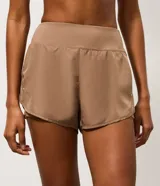 Short runner deportivo 2x1 de microfibra color bordó, con cintura elástica, bolsillo funcional con cierre y bajo redondeado.
