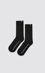 Pack de dos pares de medias de algodón con tejido acanalado, una en color blanco y otra en color negro. Presentan una etiqueta pequeña con el logo de tijeras en el borde superior.