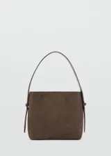 Bolso de hombro de tamaño mediano confeccionado en piel de serraje color marrón. Presenta un diseño estructurado con asa corta ajustable y cierre mediante botón magnético interior.